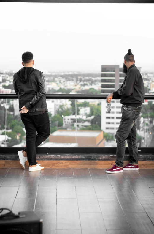 two men stand in the middle of a balcony