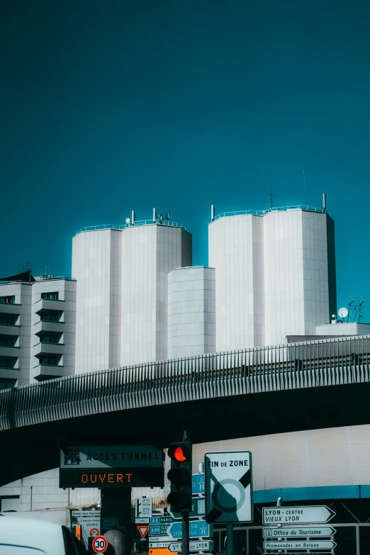 cars driving under a bridge in a city