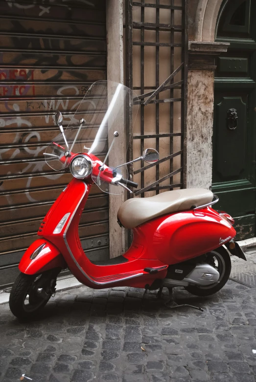 a scooter parked on the side of the road in front of a doorway