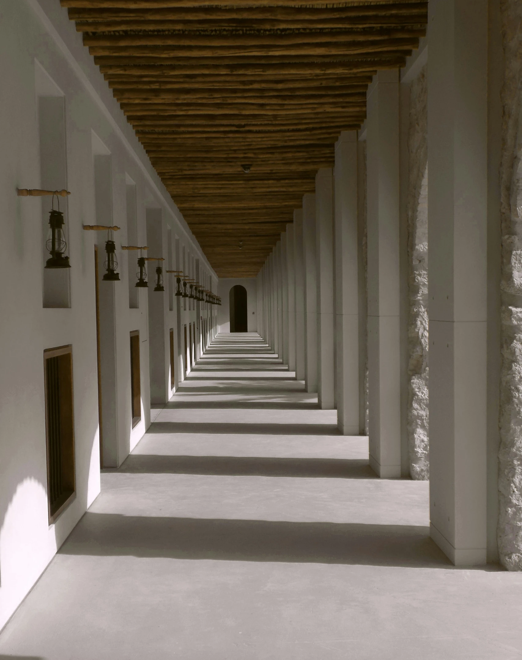 a very long hallway lined with long white pillars