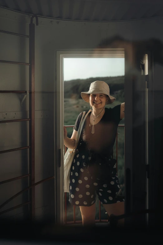 woman with hat and shorts walking on porch next to a doorway