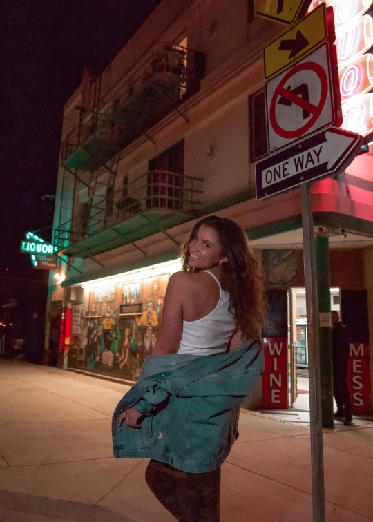 a woman is standing next to a sign