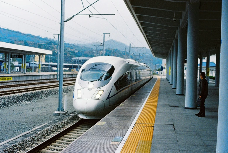 a sleek white bullet train pulling into a station