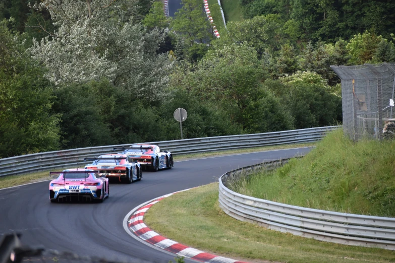 four racing cars racing down the track at an unknown point