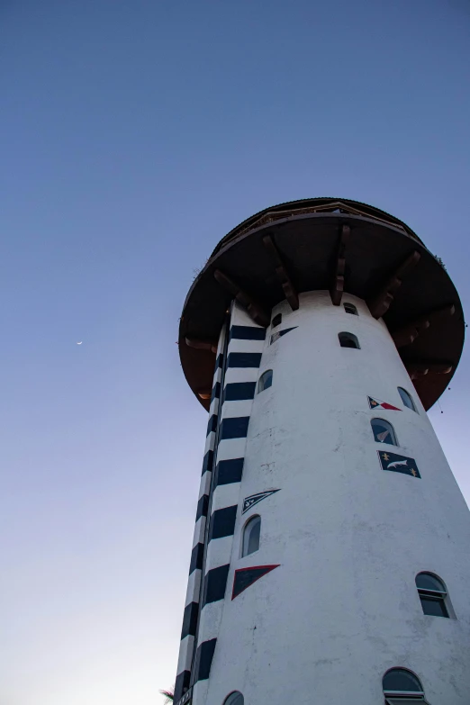 a big white tower with windows and a sky background