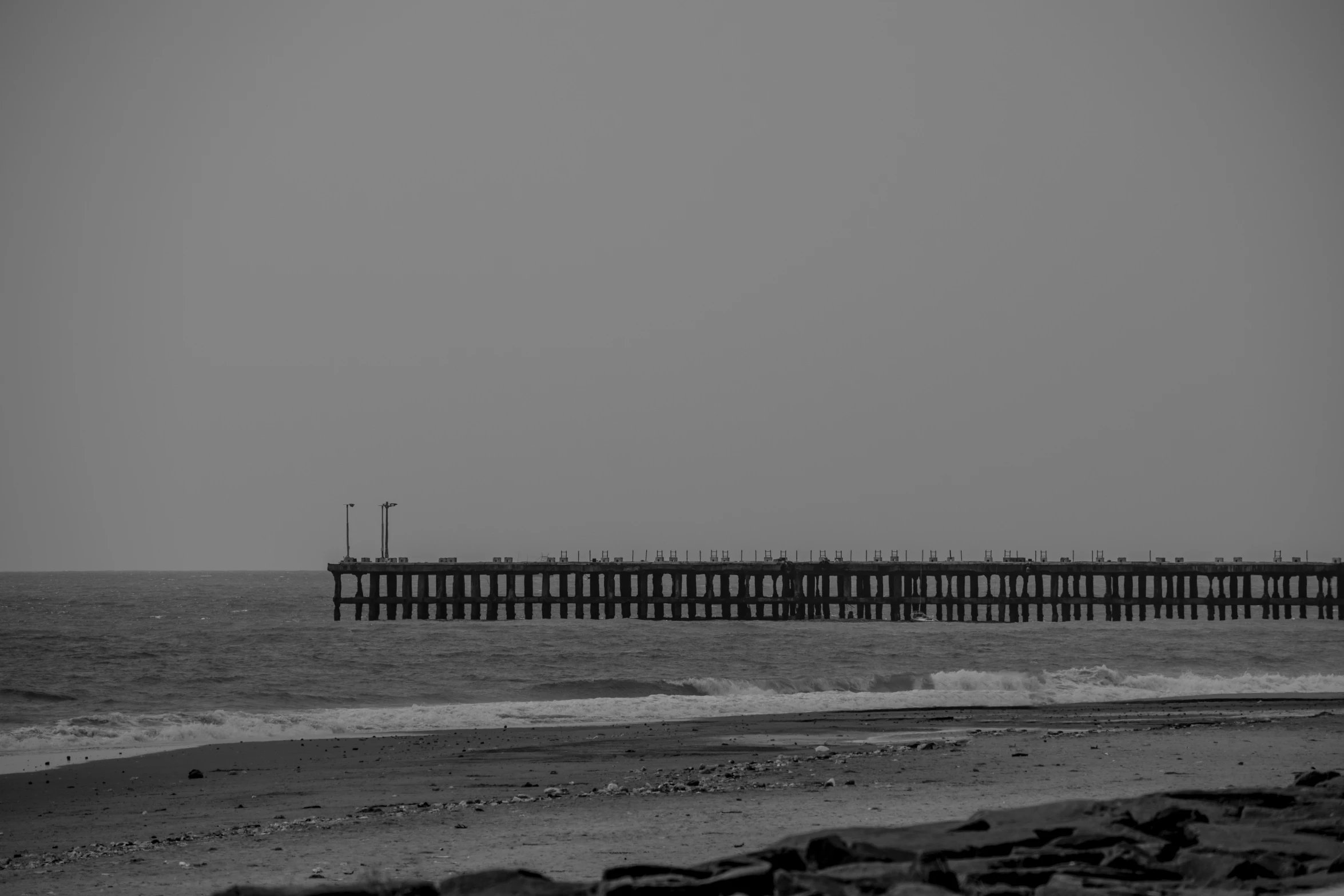 a large dock line over the ocean by the beach