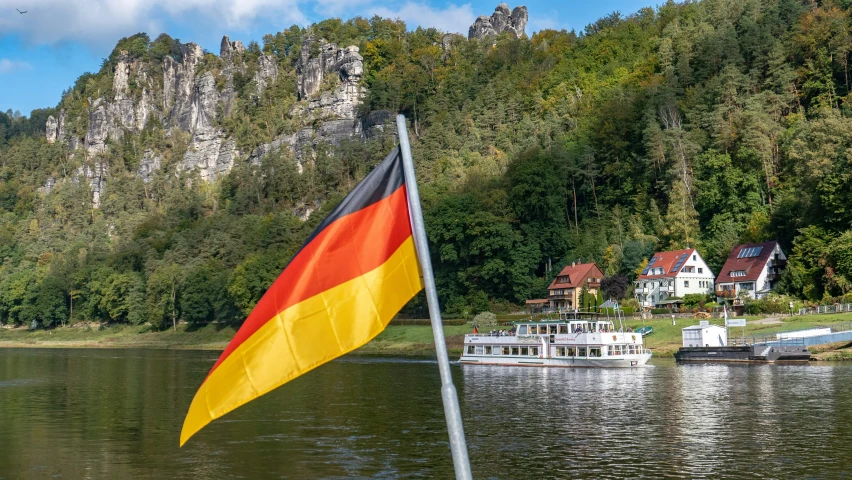 there is a flag on the boat in the water