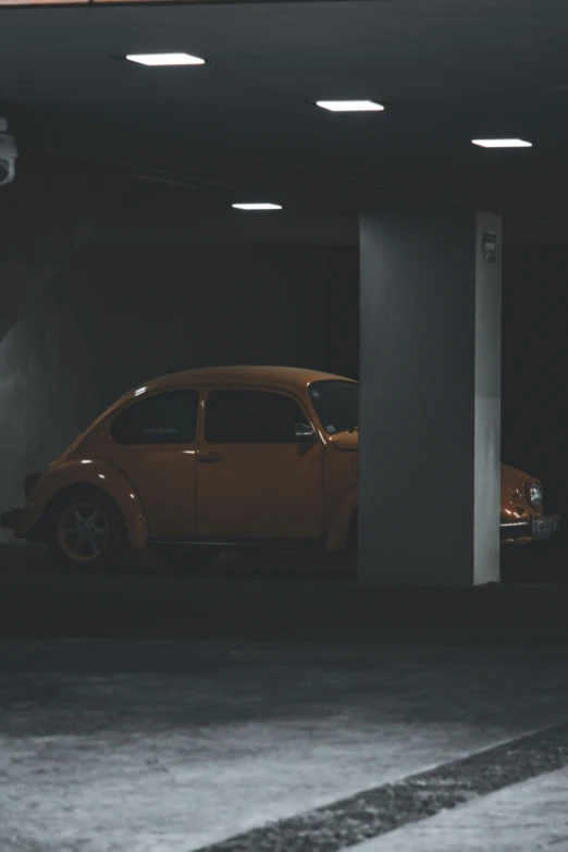 a yellow volkswagen beetle sitting inside of a car parking garage