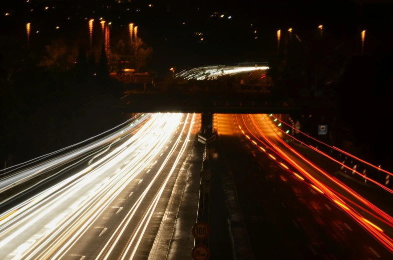 cars are riding down a busy city highway at night