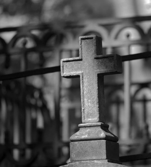 a close up of a cross on a pedestal outside