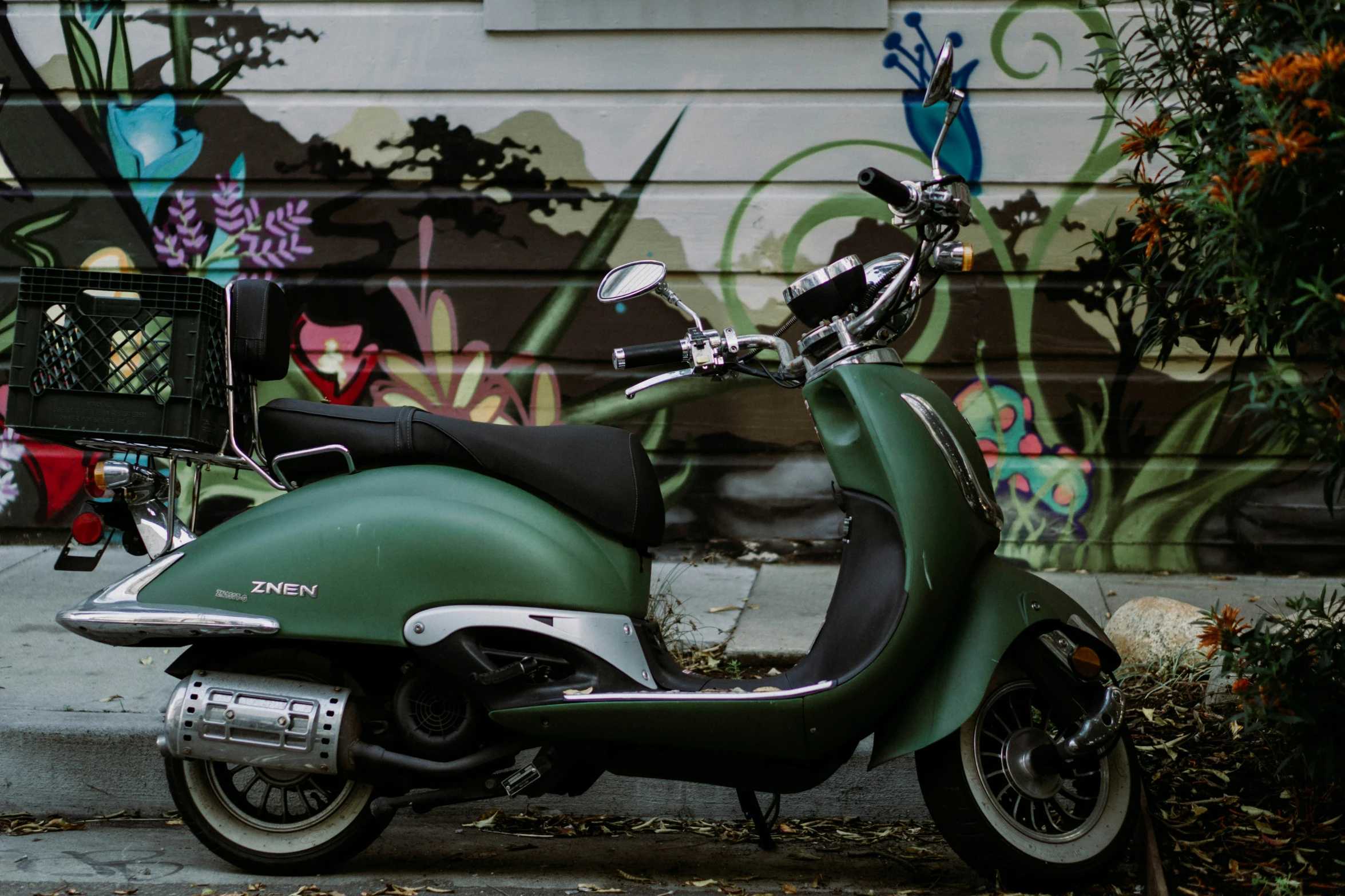 a very shiny green and black motorcycle in front of graffiti