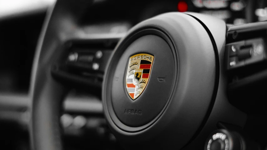 a porsche emblem on the steering wheel of a car