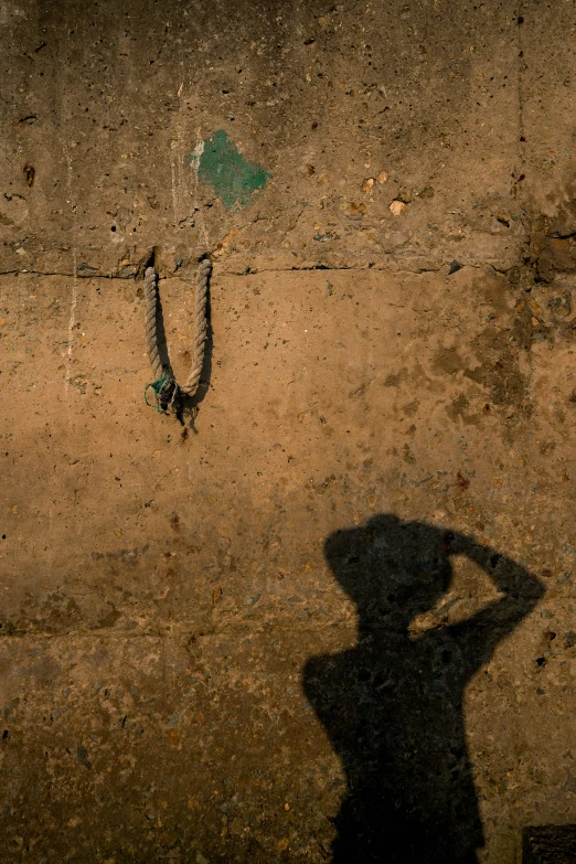 a shadow in the dirt of a man holding a tennis racquet