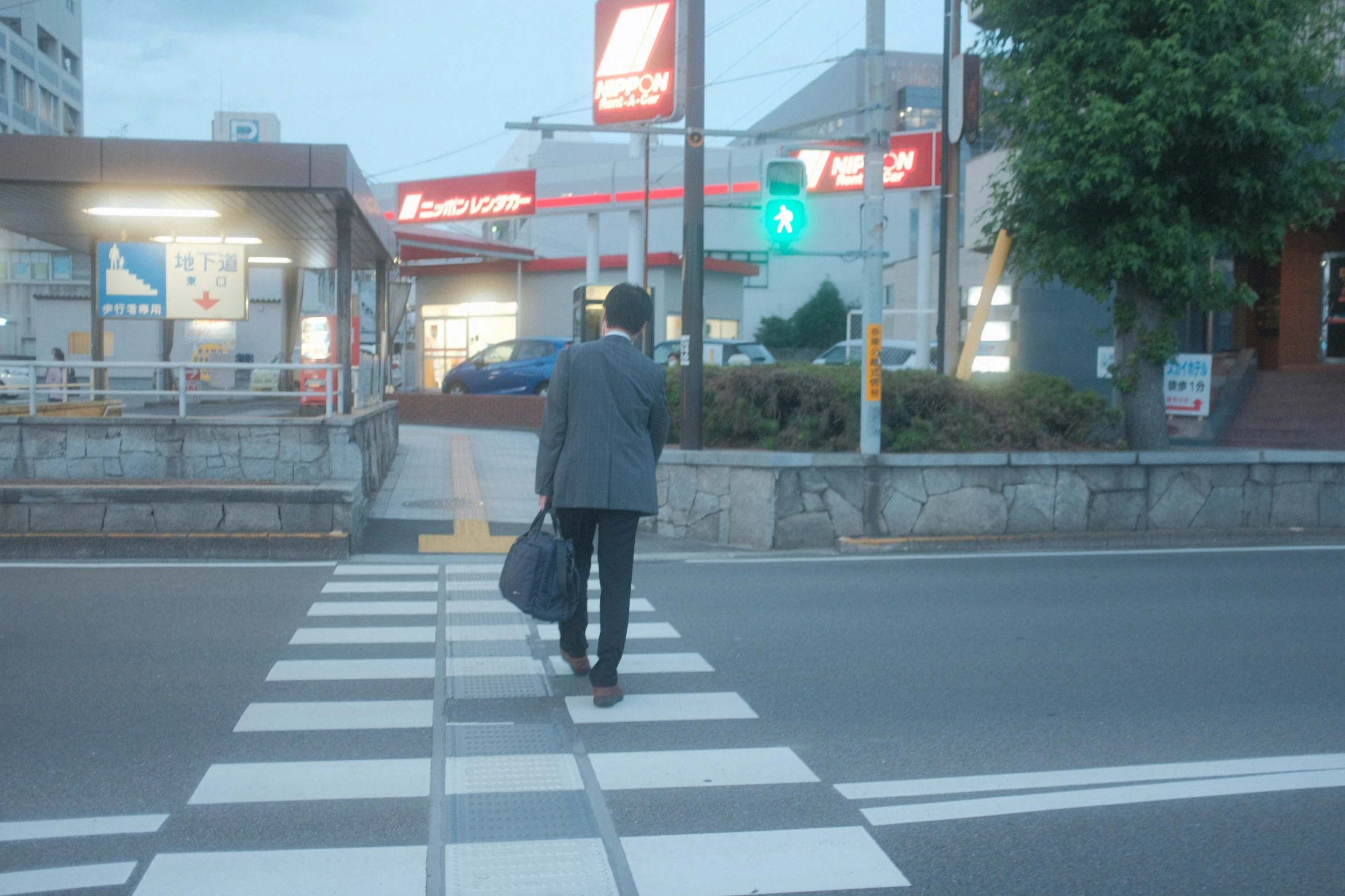 man walking through street with bag in his hand