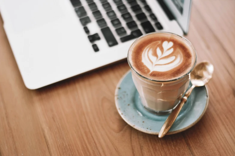 a cup of latte art on top of a blue saucer