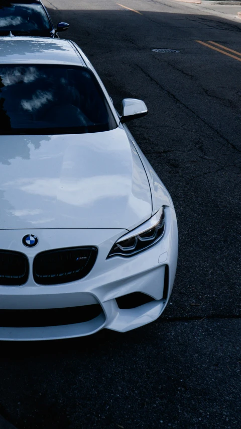 white car parked on the street in the shade