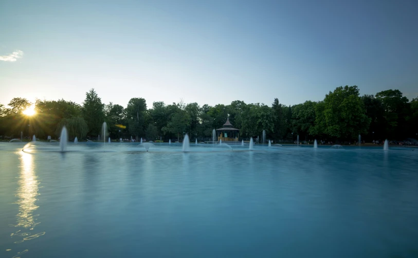 the sun is shining over a large pool of water