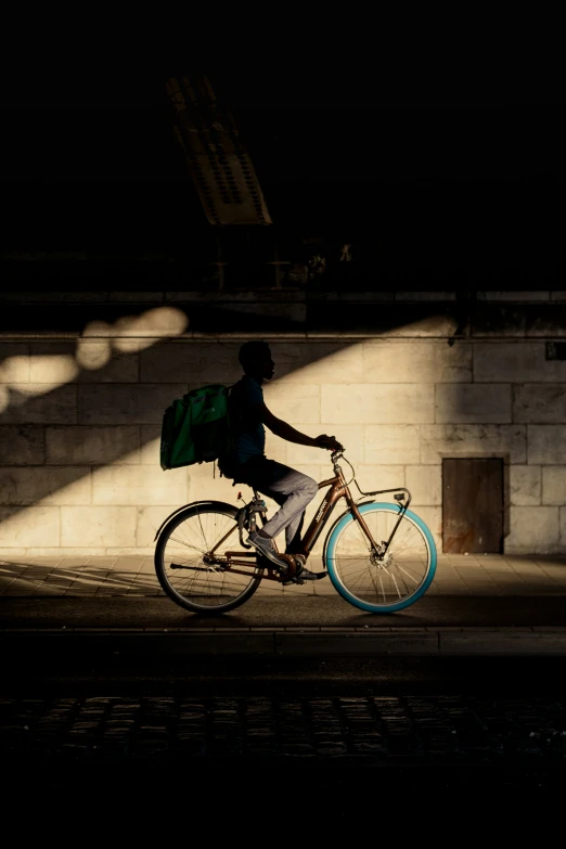 a person on a bike with a green bag strapped to it's seat