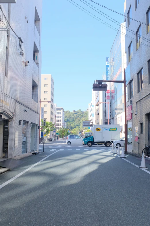 a city street with buildings and cars coming around