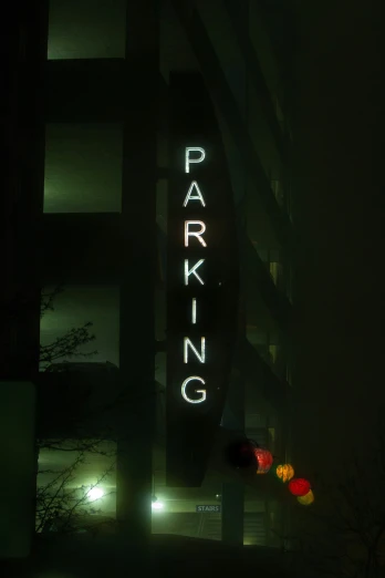 a dark parking sign is lit up with the word parking