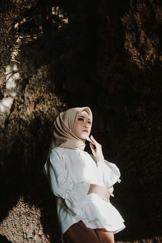 a woman is sitting under a tree in an old fashion dress