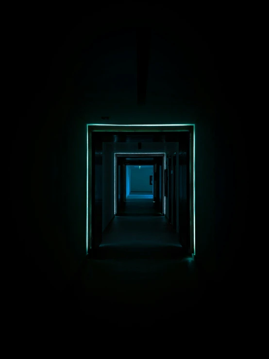 an empty dark hallway has lights on it