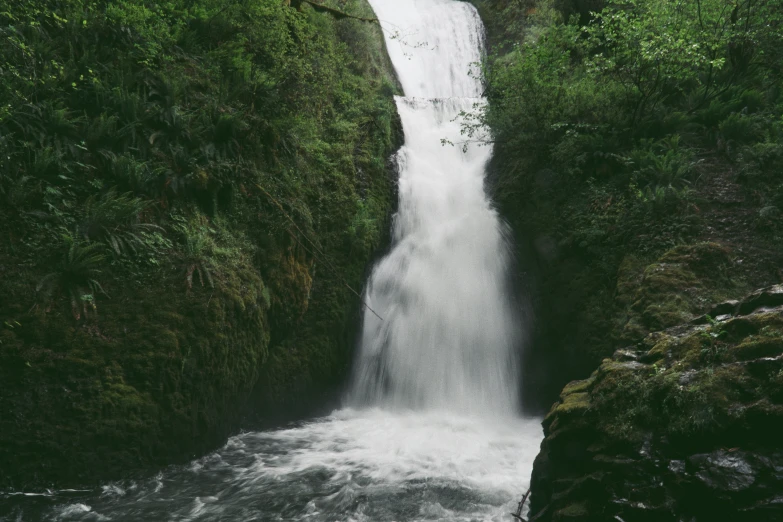 a waterfall running into a small deep body of water