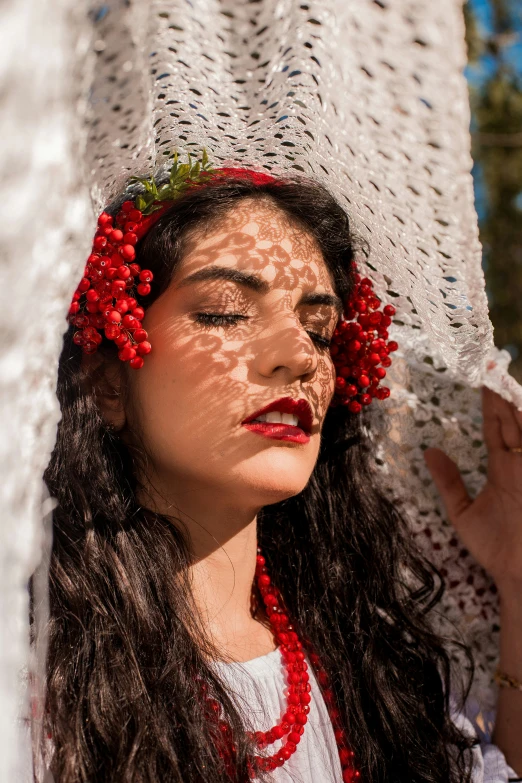 a beautiful young woman in red necklace and white hat