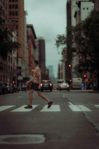a man in short shorts and sneakers crossing a street
