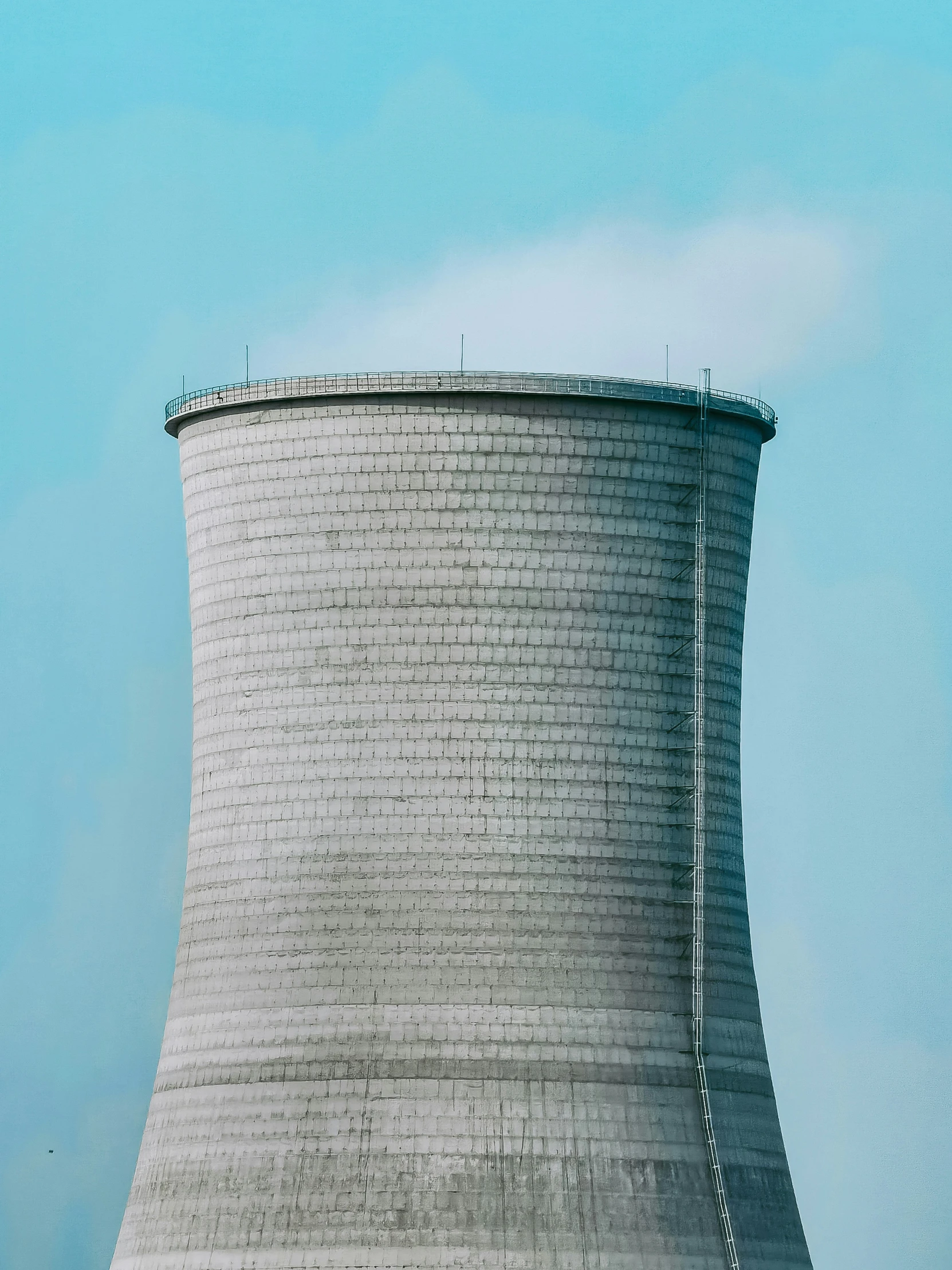 a large cooling tower near a building with windows