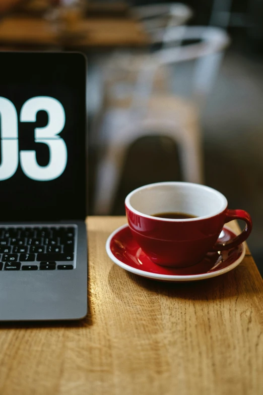 a laptop computer and coffee mug sitting on a table