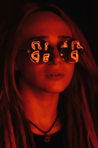 woman with glasses with the image of three snakes lit up on her face