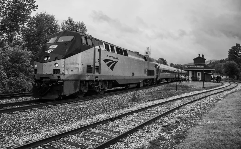 black and white pograph of train sitting on railroad tracks