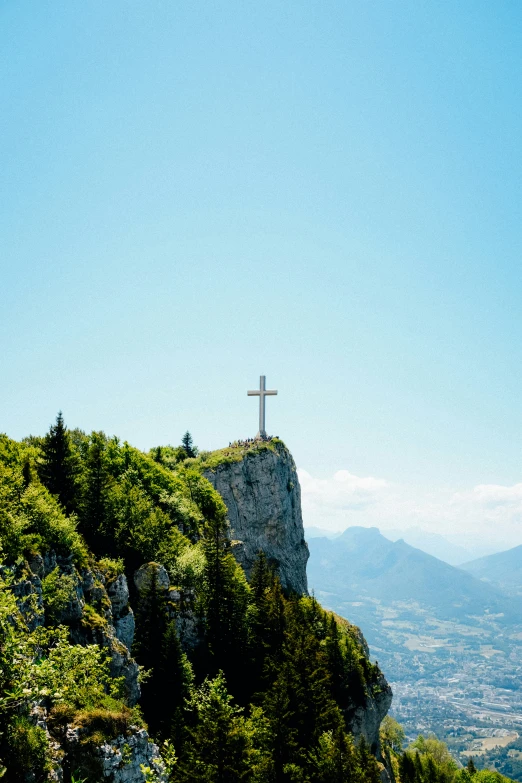 a hill that has some trees and a crucifix on top