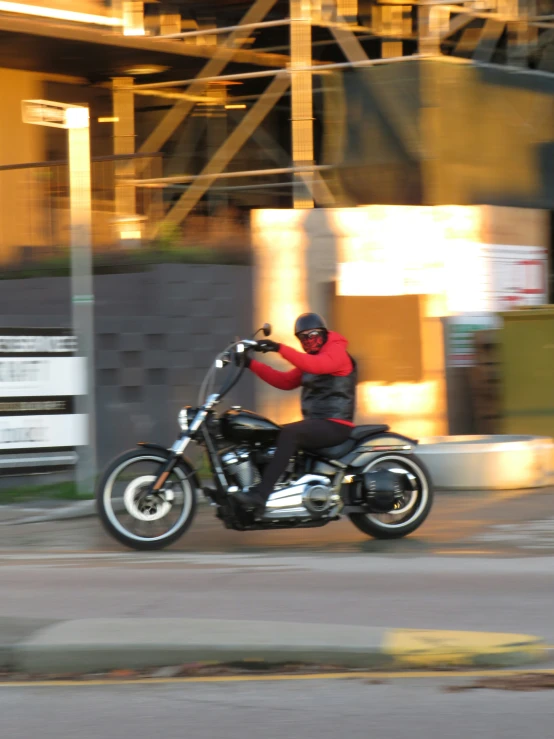 a person riding a motorcycle near a building
