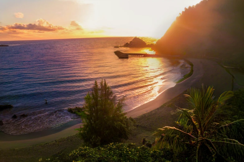 the sunset lights up the water at the beach