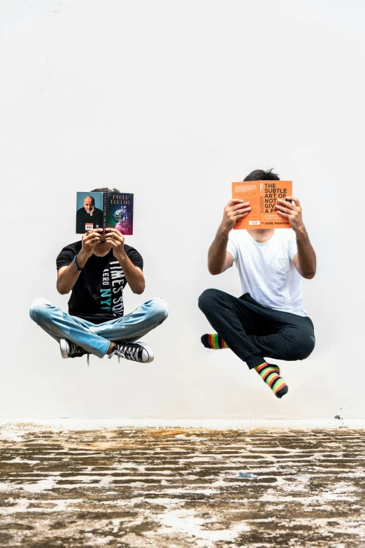 two people flying through the air while holding books