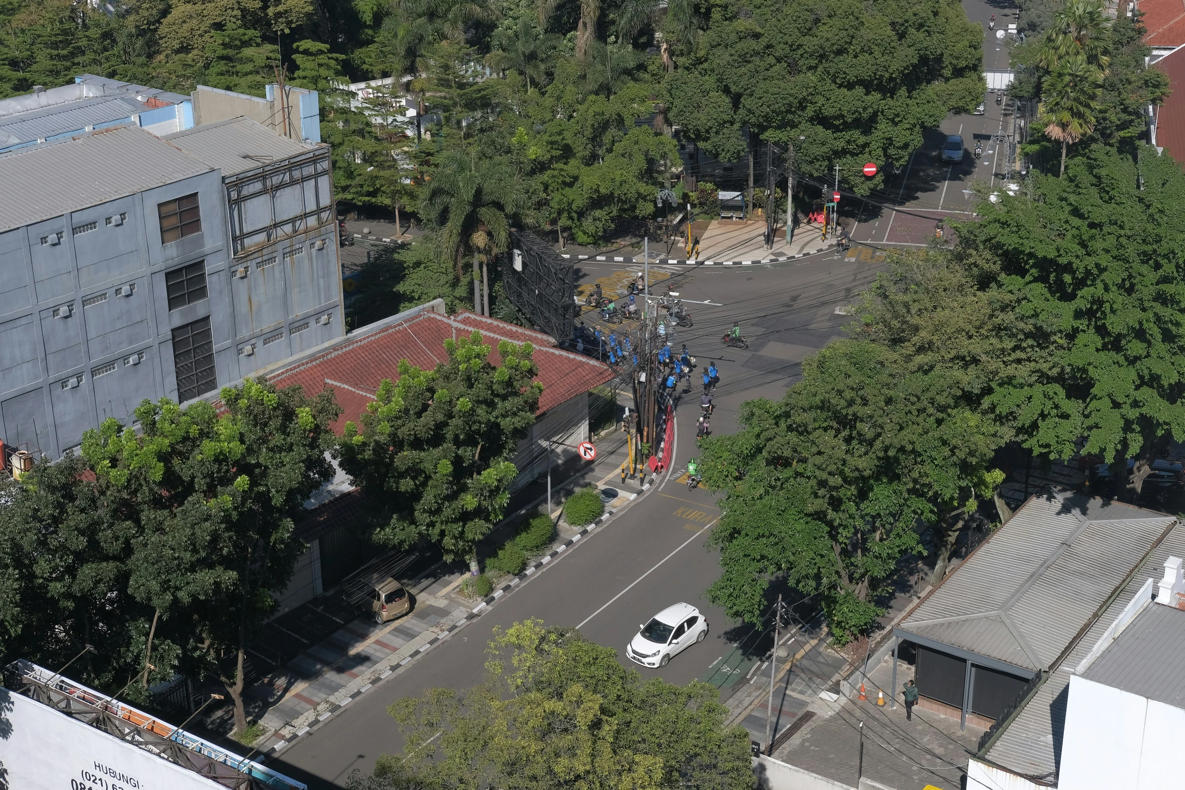 an aerial view of trees and cars in front of buildings