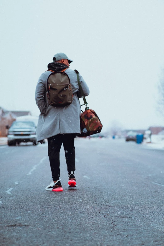 a man walking down the road carrying some luggage