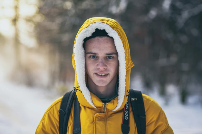 a young man wearing a snow coat in the snow