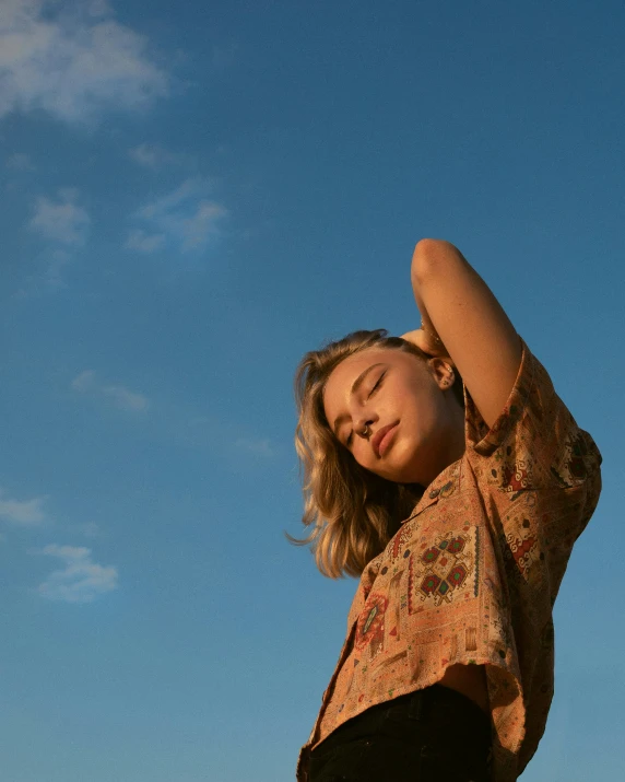 a woman in a dress posing for a picture against a blue sky