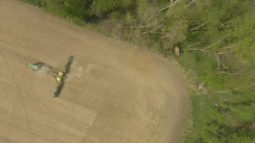 two tractors are working in a field