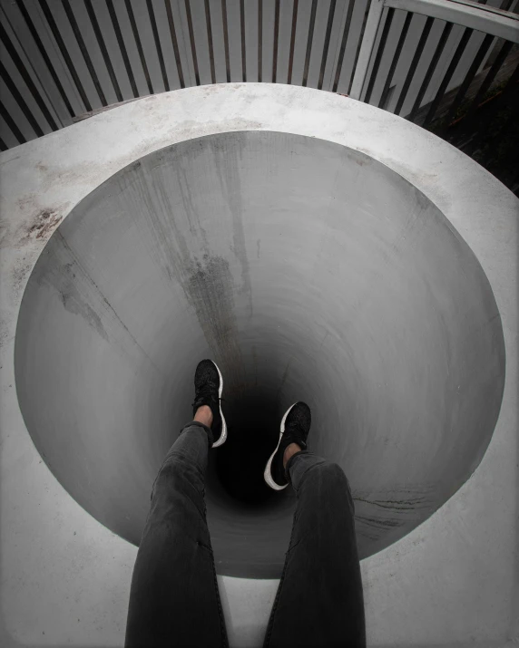 the legs and feet of a person standing in the toilet