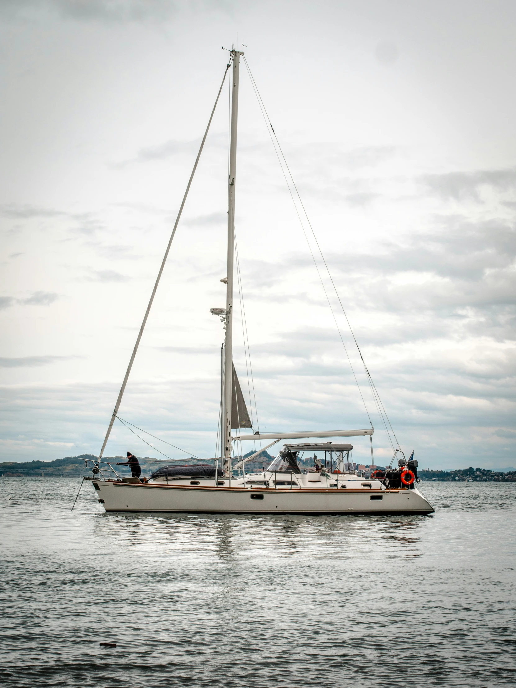 a sailboat on the water with people around it