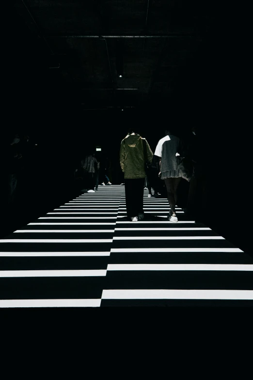 people walking across a ze crossing at night