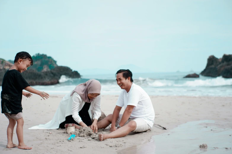 a couple and two children playing on a beach