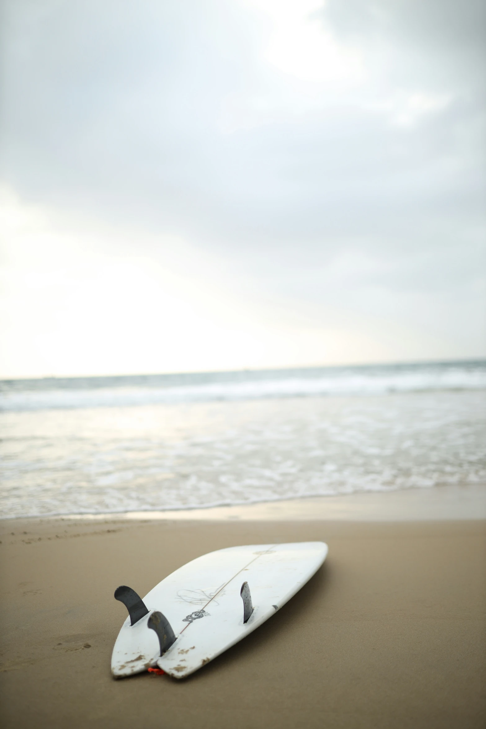 there is a surfboard lying on the beach shore