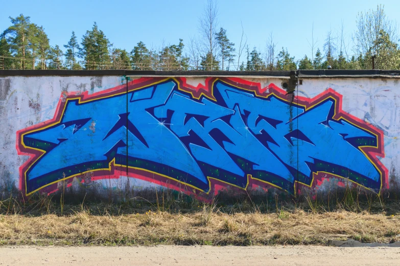 a graffiti wall has blue and red letters on it