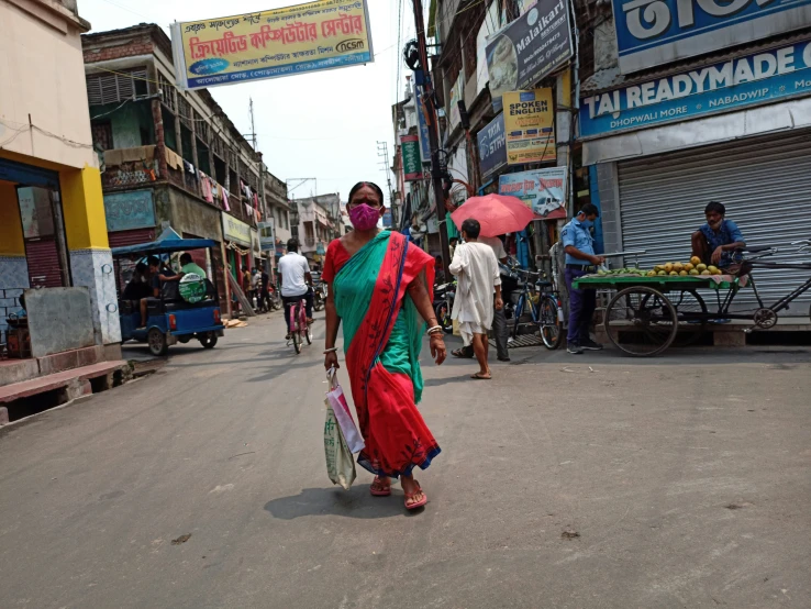 woman in sari walking down the street of a small town