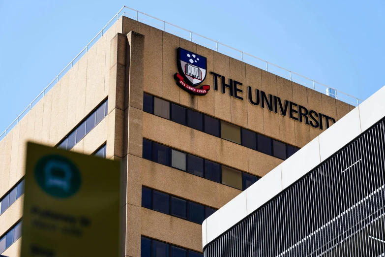 the university sign is seen above the top of a building